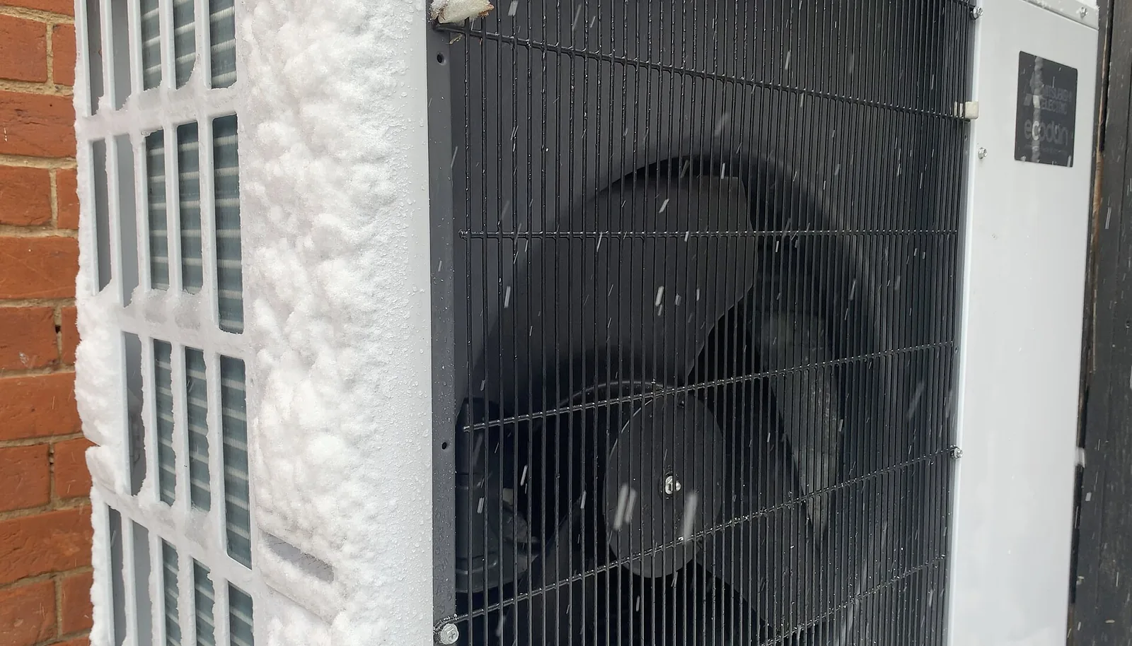 Frost built up on an outdoor heat pump coil in snow
