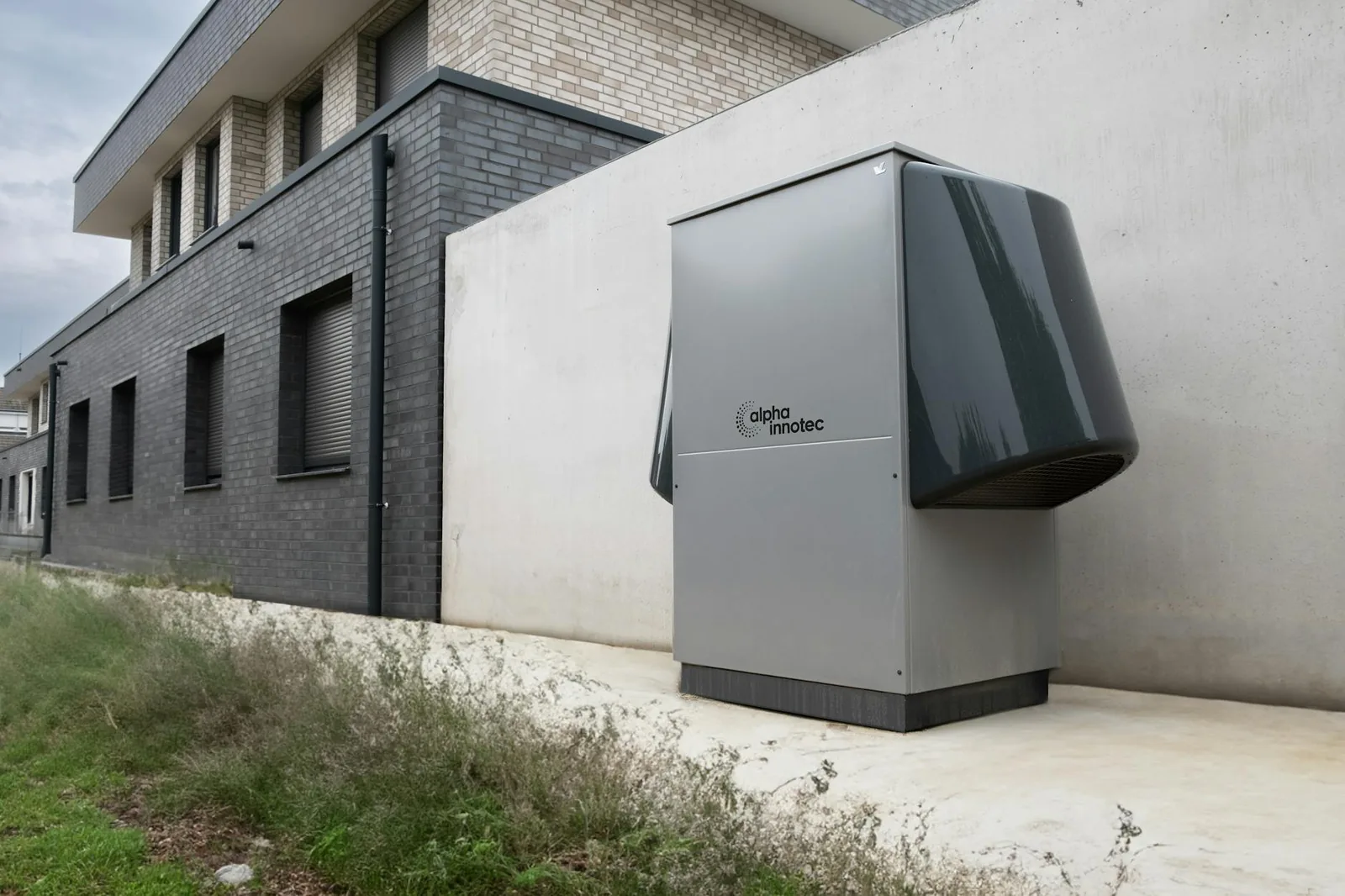 A modern outdoor heat pump unit installed alongside a contemporary residential building.