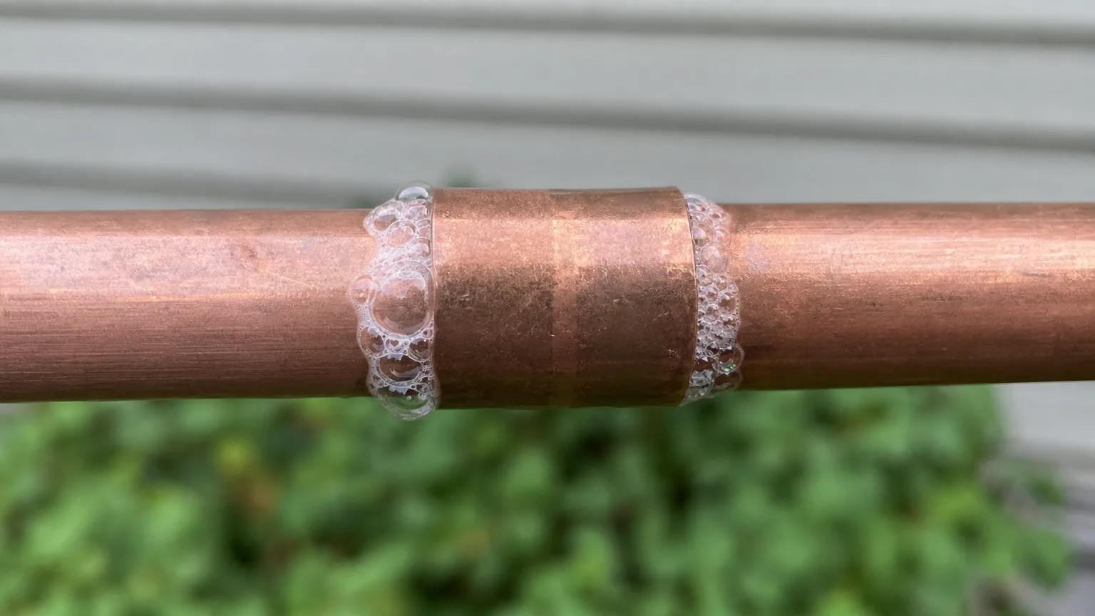 Soap bubbles forming at a copper pipe joint