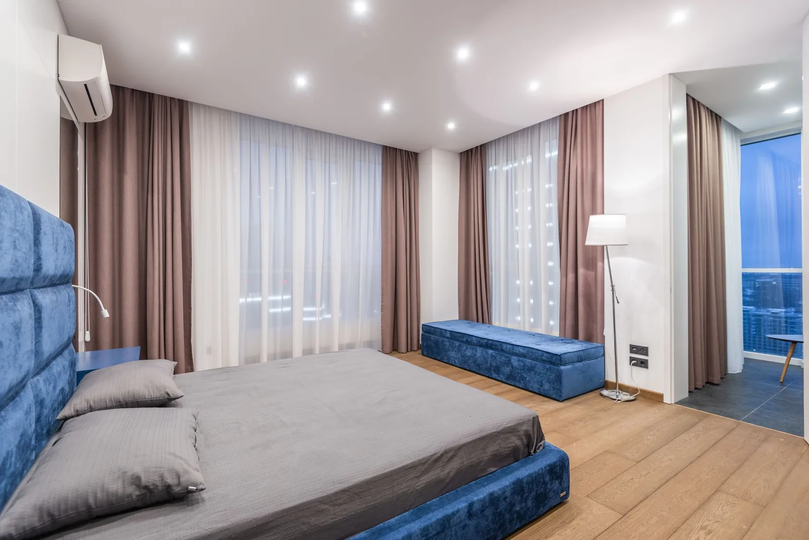 Wall-mounted ductless mini-split head in a curtained bedroom