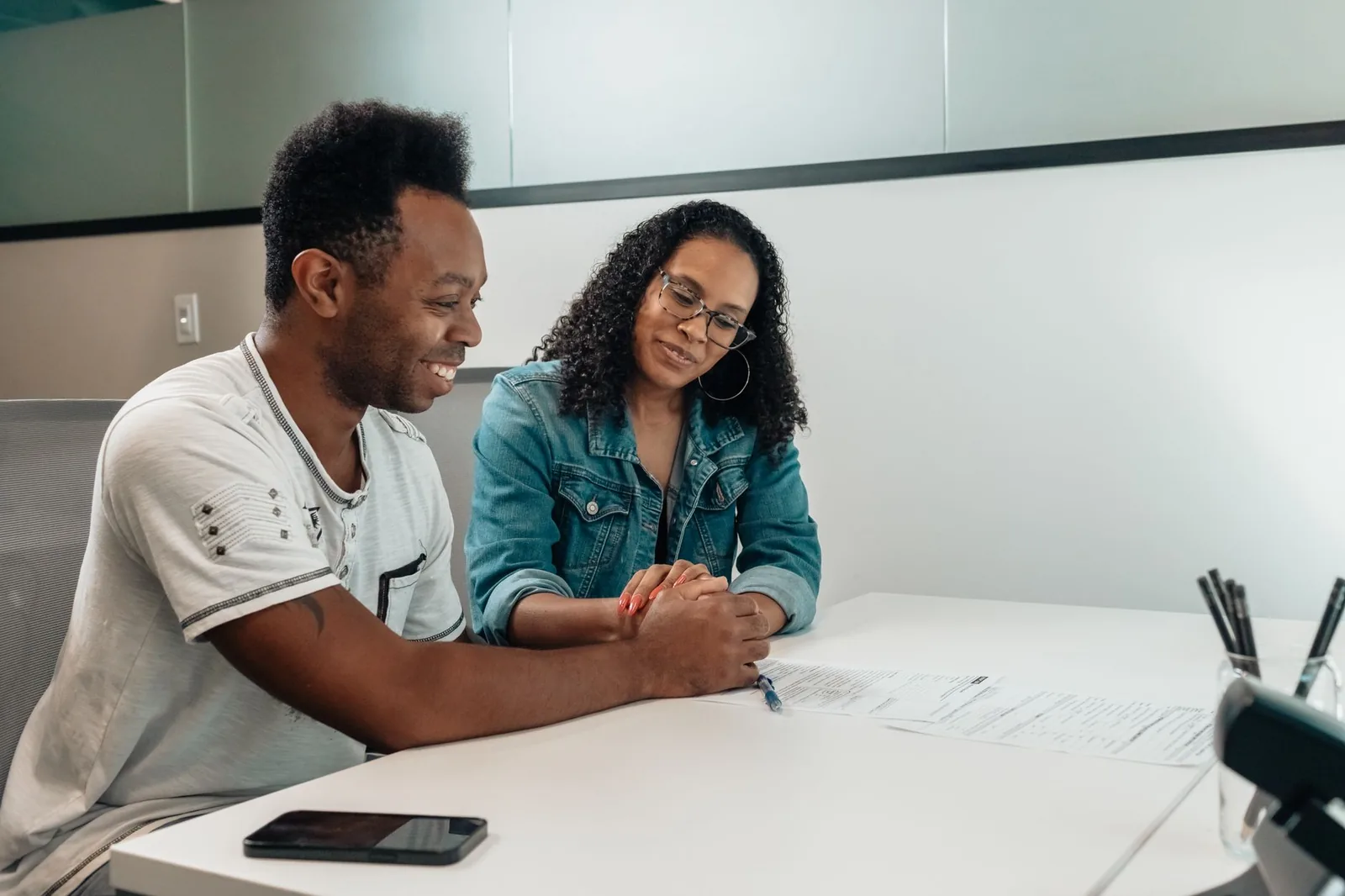 Couple signing a document at an office table