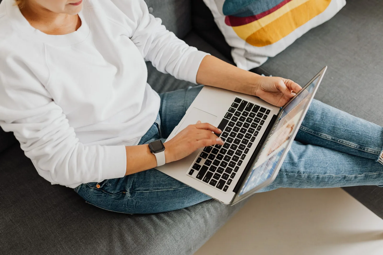 Person using a laptop while sitting on a sofa