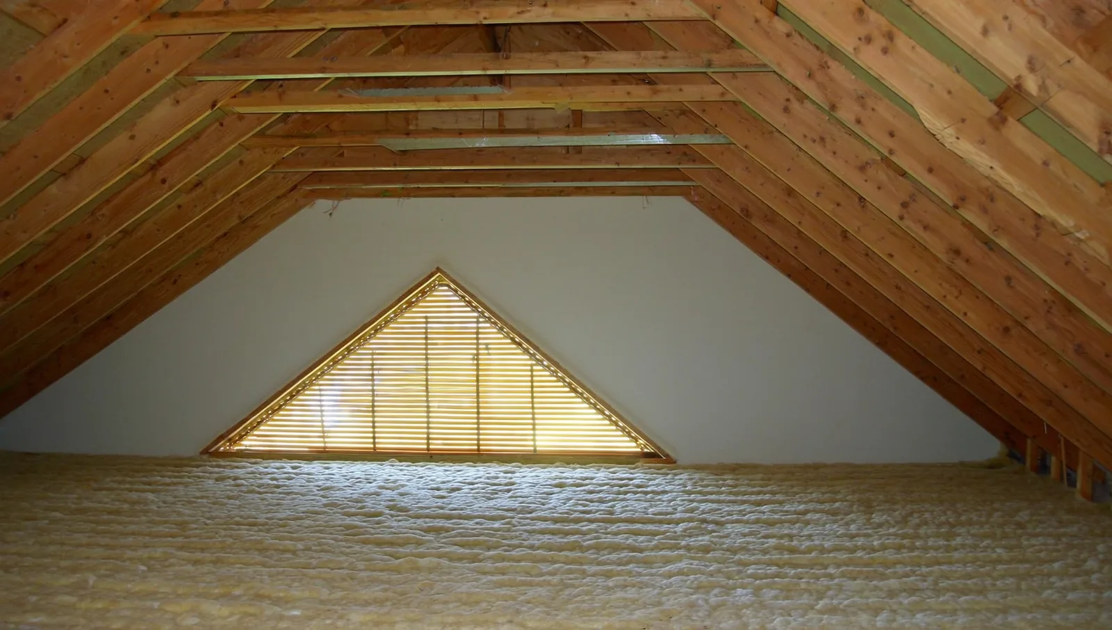 Attic rafters above insulation with a gable vent